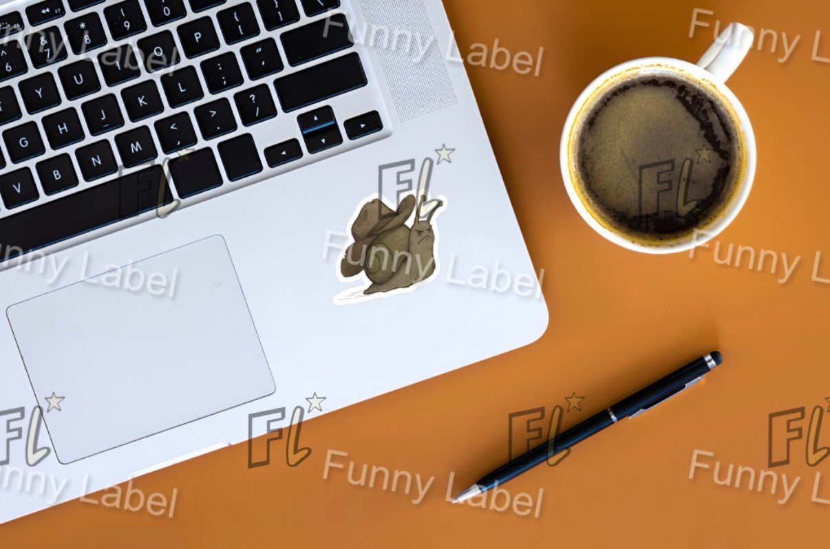 Laptop with a sticker on a brown surface next to a cup of coffee and a pen.