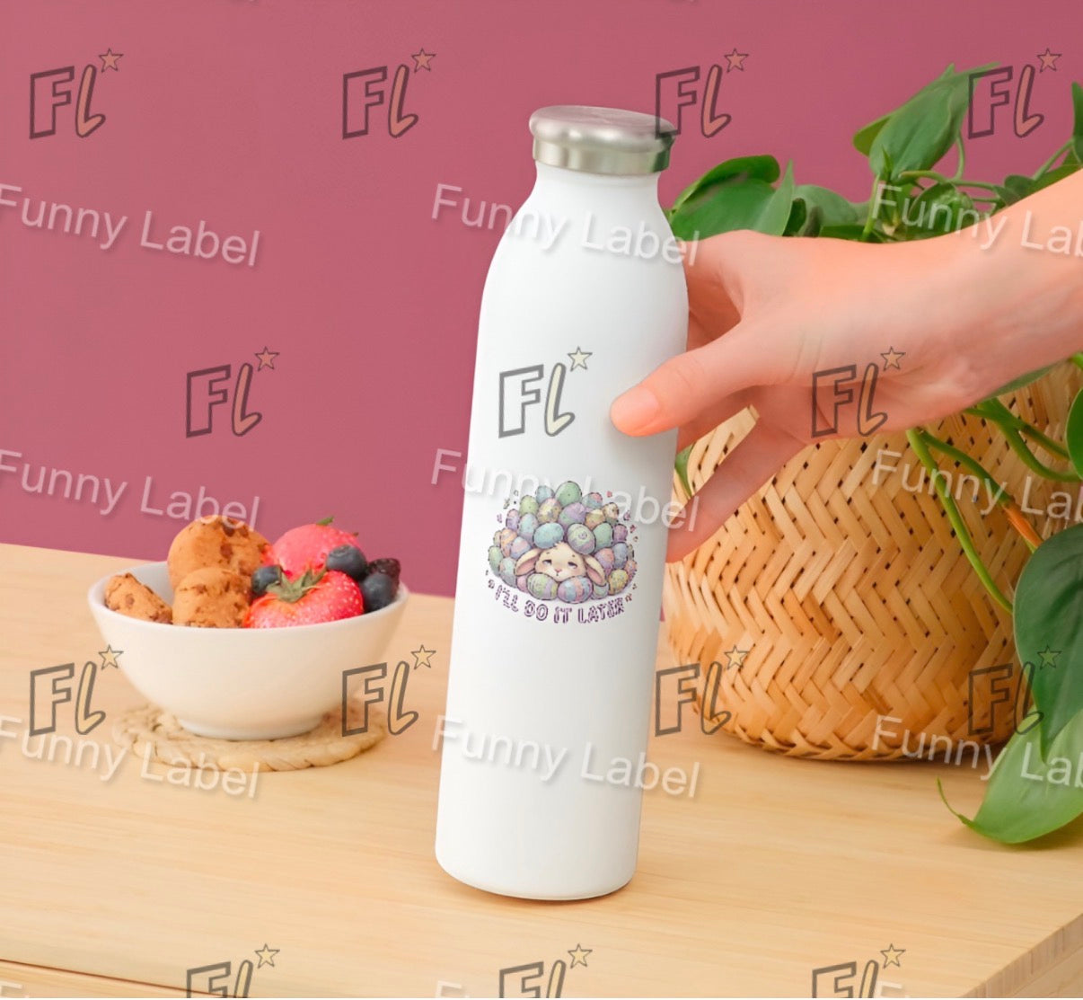 White water bottle with 'FL' branding held by a hand on a wooden surface with a bowl of fruit and basket in the background.