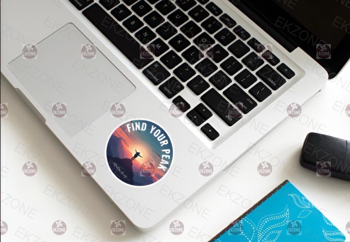 Laptop with a 'Find Your Peak' sticker on a white surface
