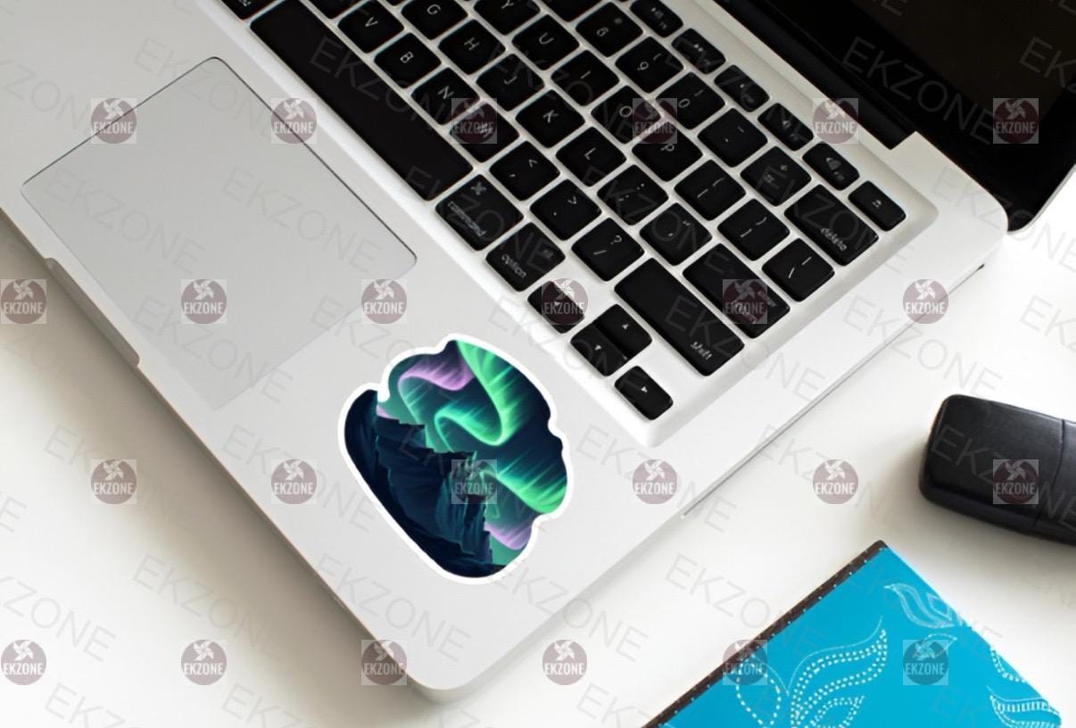 Laptop with a colorful decal on the palm rest area, placed on a white surface.