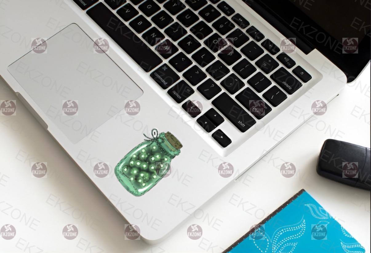 Laptop with a green sticker on a white surface