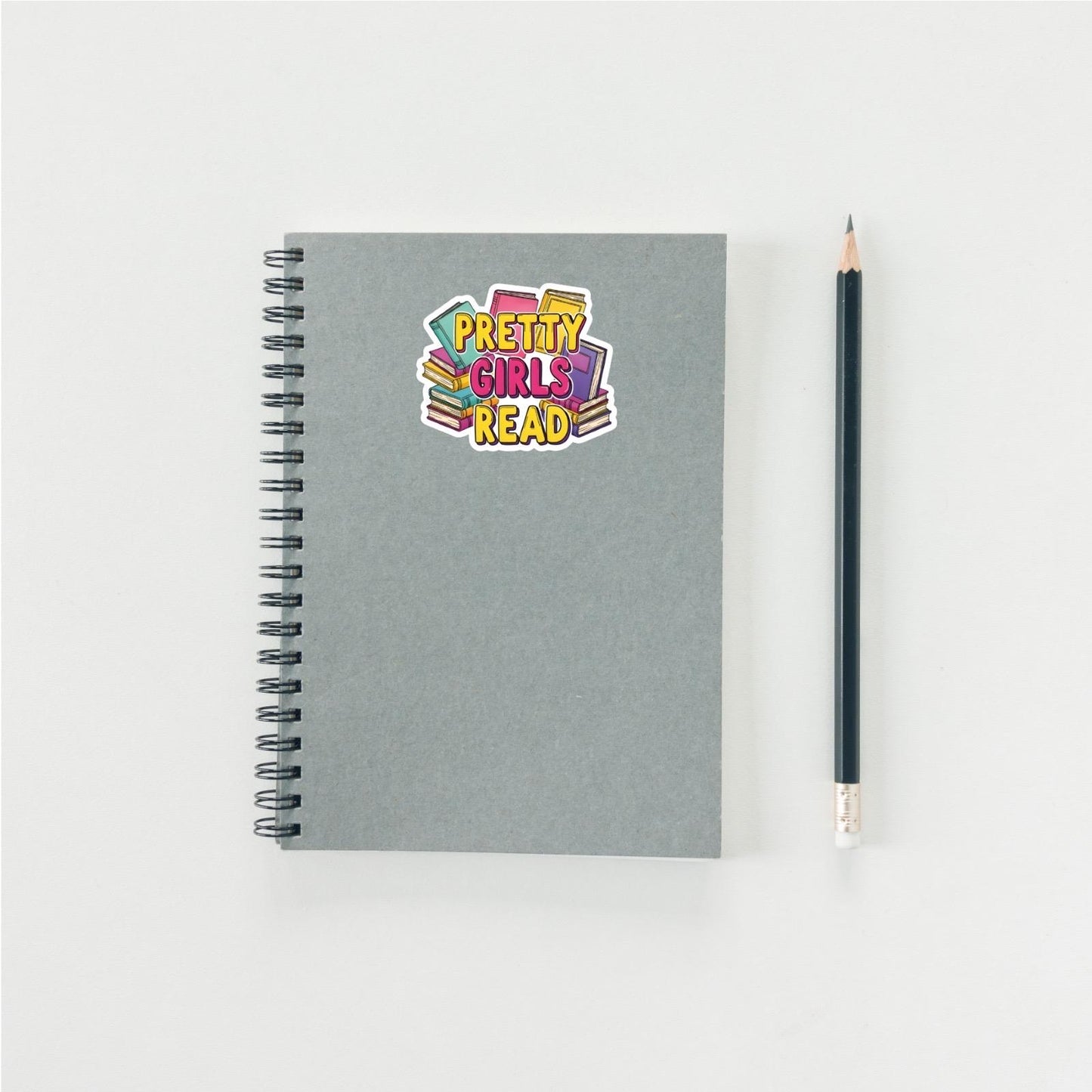 Gray notebook with a colorful sticker and a pencil on a white background