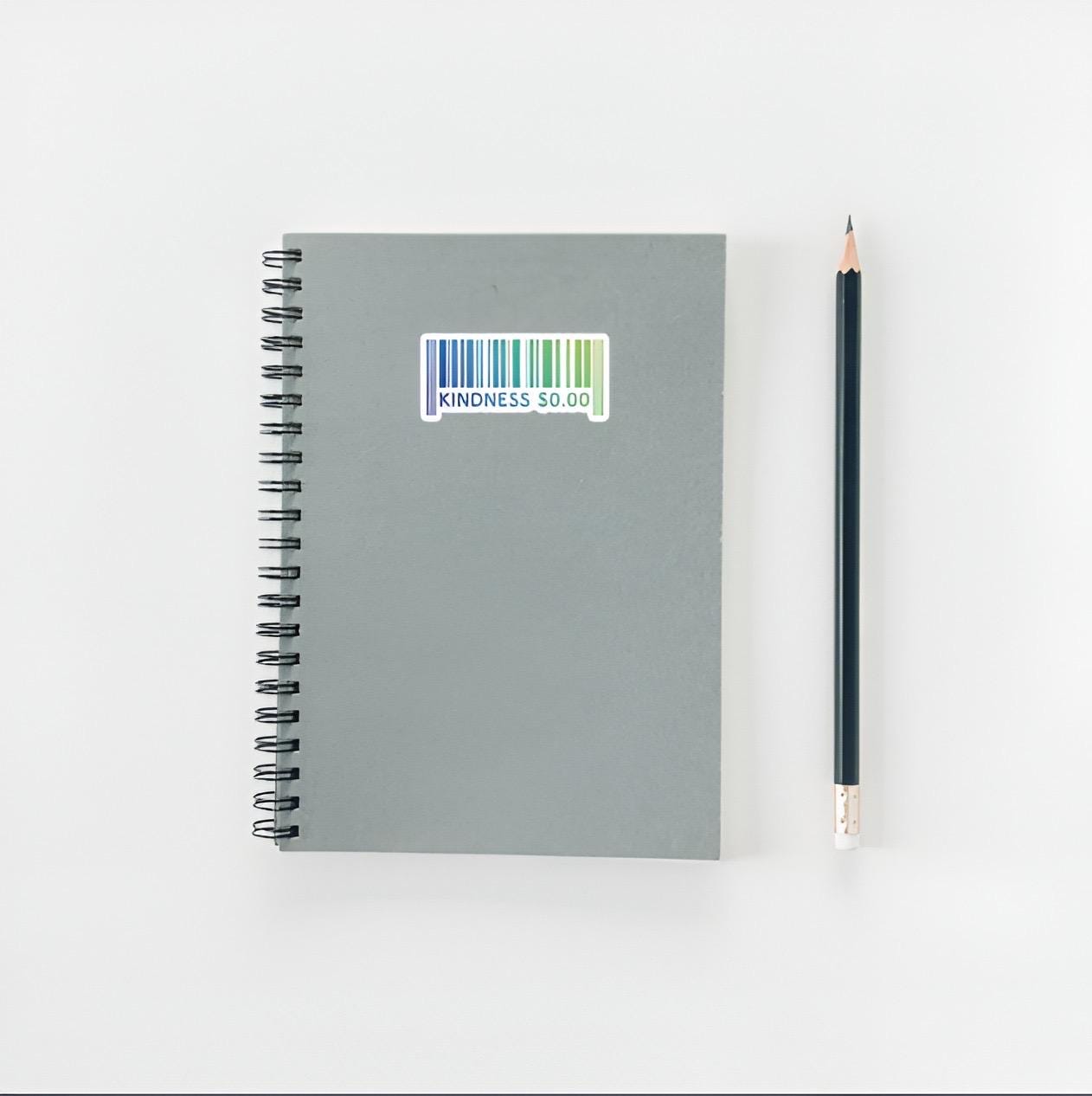 Gray notebook with a barcode label and a pencil on a white background