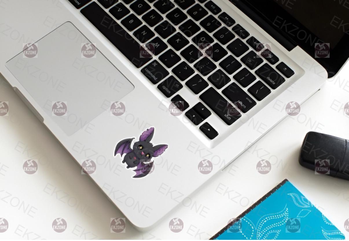Laptop with a purple bat-shaped sticker on a white surface