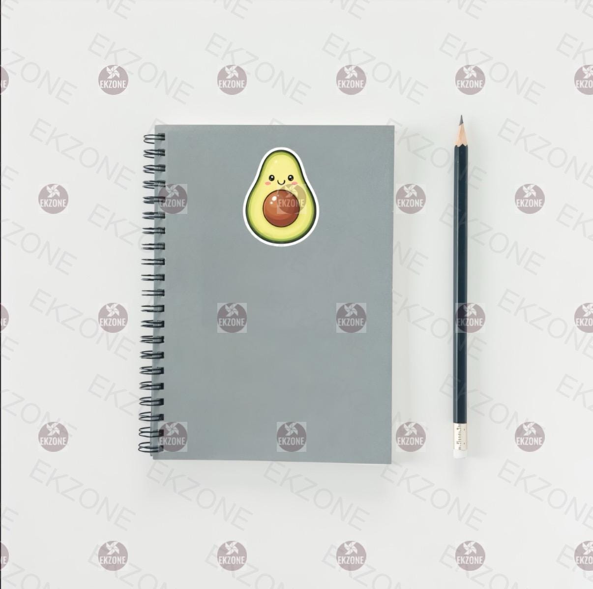 Gray notebook with avocado sticker and pencil on a white background