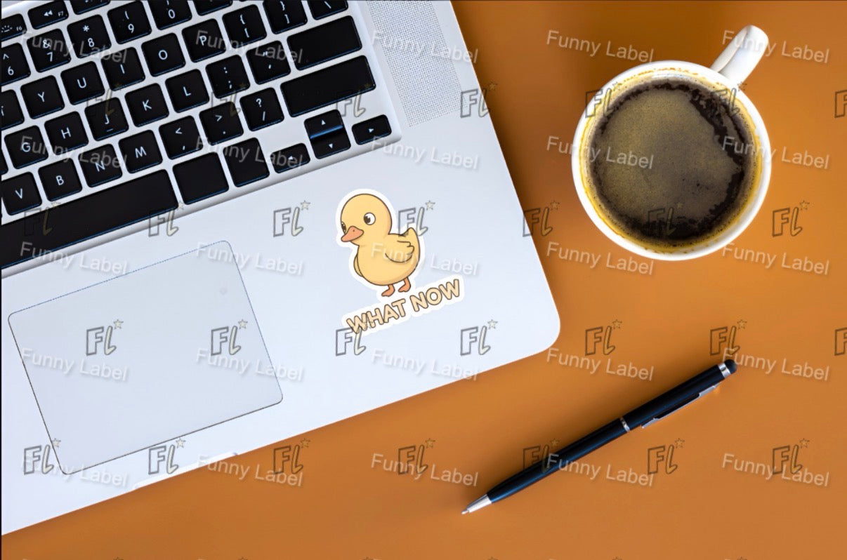 Laptop with a yellow duck sticker on a brown surface with a coffee cup and pen.