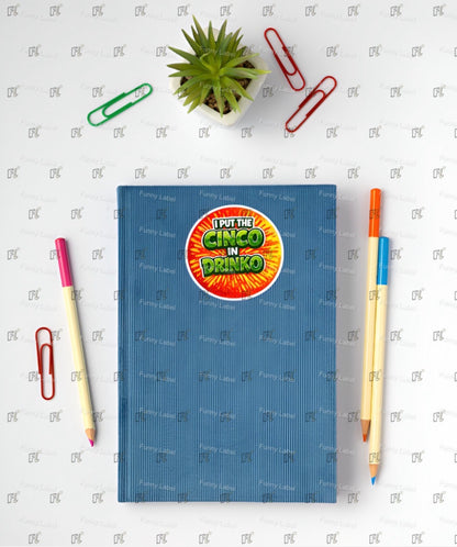Blue notebook with a colorful sticker on a white surface with stationery items.