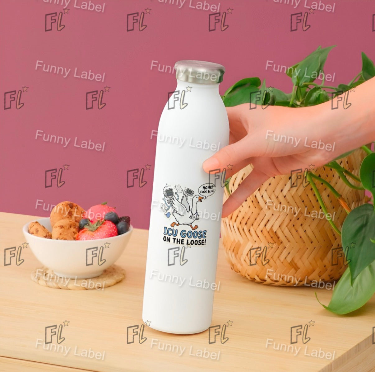 White bottle with cartoon design held by a hand on a wooden surface with a bowl of fruit and basket in the background.