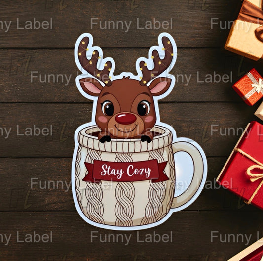 Reindeer in cable-knit mug sticker with “Stay Cozy” banner and festive lights