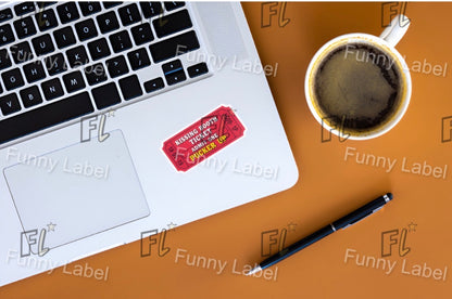Laptop with a sticker on a wooden surface next to a cup of coffee and a pen.