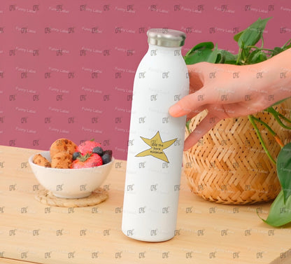White water bottle with star design held by a hand on a wooden surface with fruit and cookies.