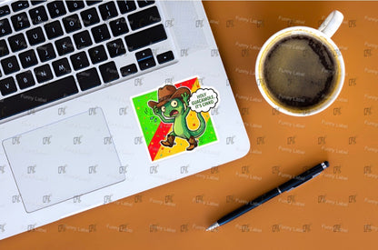 Laptop with a sticker of a cartoon dragon, a cup of coffee, and a pen on a wooden surface.