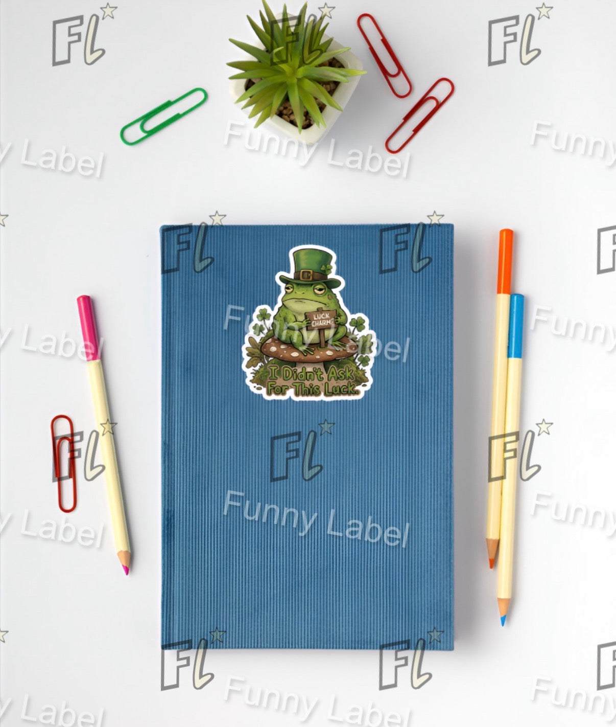 Blue notebook with a frog sticker on a white background with stationery items.