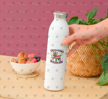 White water bottle with colorful design held by a hand on a wooden surface with a bowl of snacks and a plant.