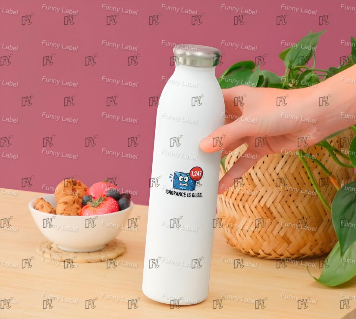 White water bottle with a logo held by a hand on a table with food and plants.