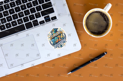 Laptop with a sticker, coffee cup, and pen on a brown surface