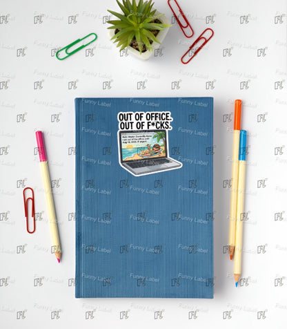 Blue notebook with 'Out of Office, Out of F*cks' text on a white background with office supplies.