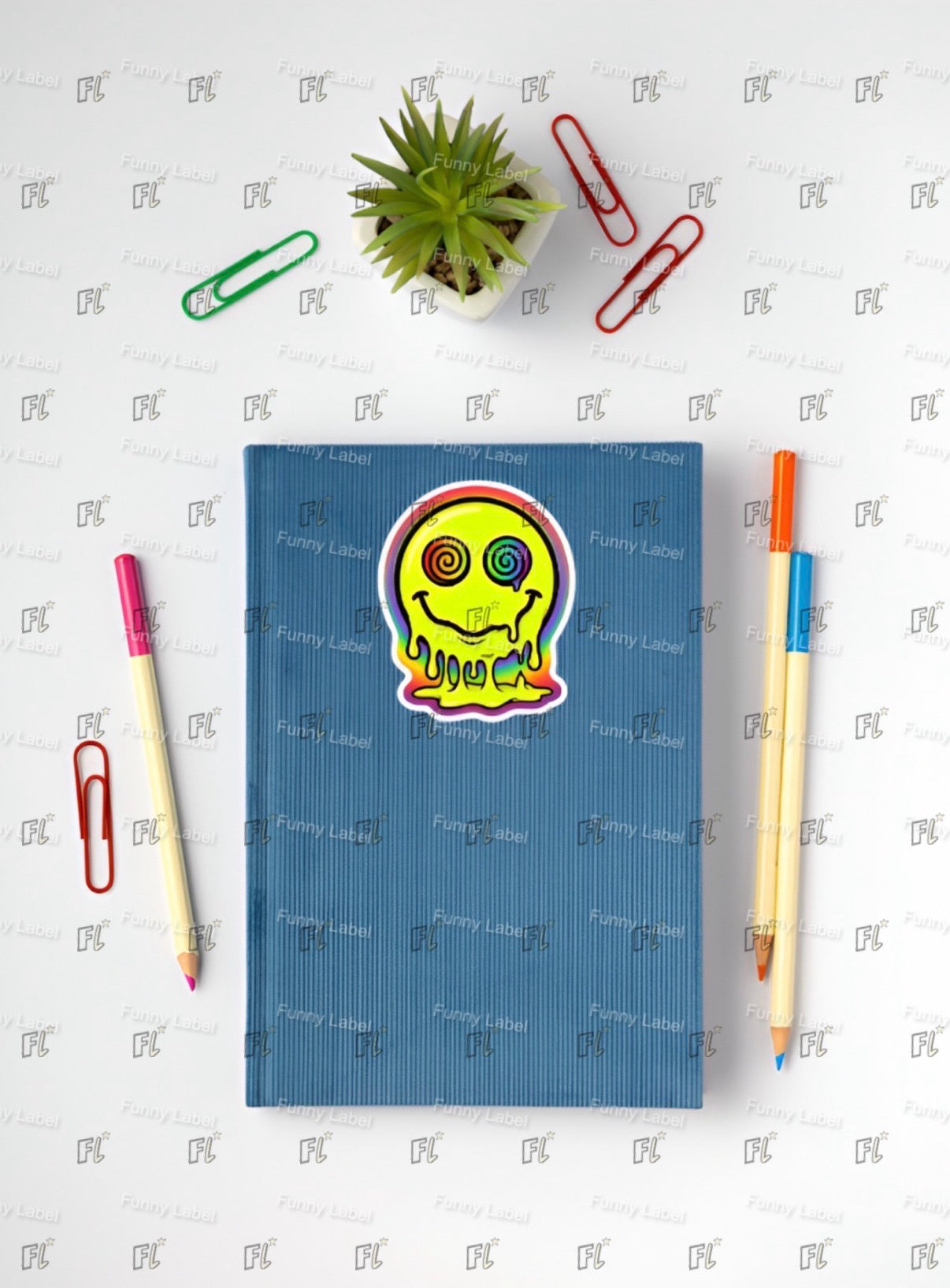 Blue notebook with a colorful sticker on a white surface with stationery items.