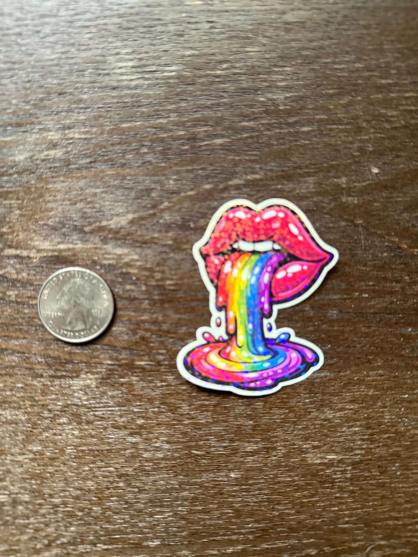 Colorful bow-shaped sticker on a wooden surface with a coin for scale.