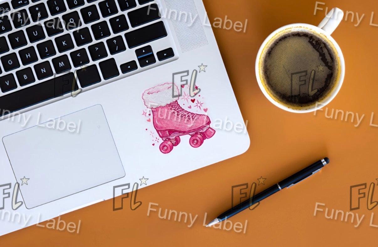 Laptop with a pink roller skate design on a brown surface with a cup of coffee and pen.
