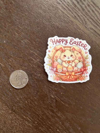 Sticker with 'Happy Easter' text and cartoon bear design on a wooden surface, next to a coin for size comparison.