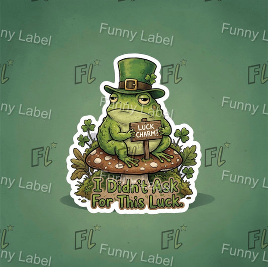 Sticker of a frog wearing a green hat with text 'I Didn't Ask For This Luck' on a green background with 'Funny Label' branding.