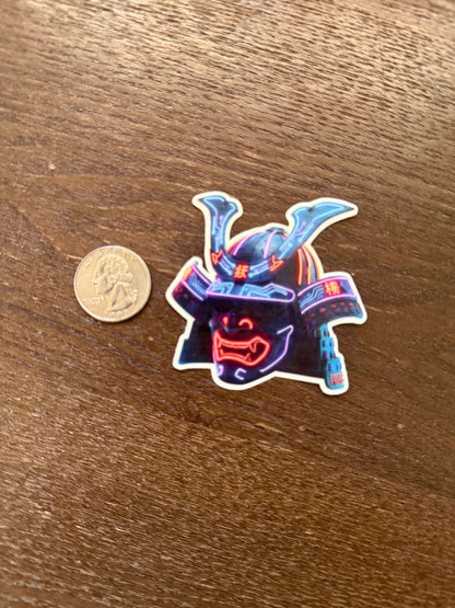 Neon-colored sticker of Neon Samurai Helmet on a wooden surface with a coin for scale.