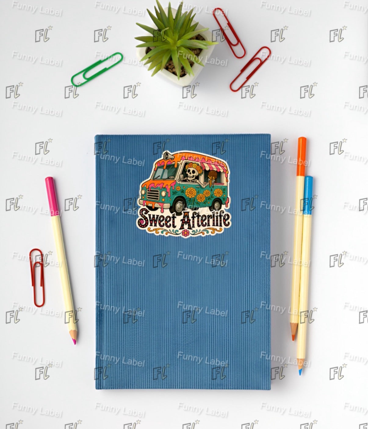 Blue notebook with 'Sweet Afterlife' design on a white background with stationery items.