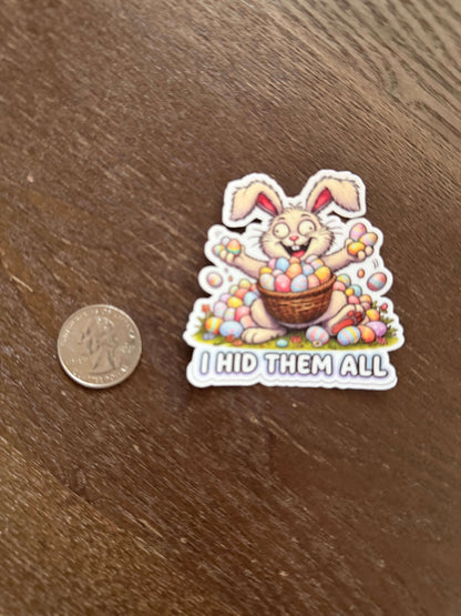 Sticker of a cartoon rabbit with a basket of Easter eggs on a wooden surface, next to a coin for scale.