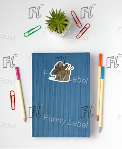 Blue notebook with a sticker on a white background with stationery items and 'Funny Label' branding.