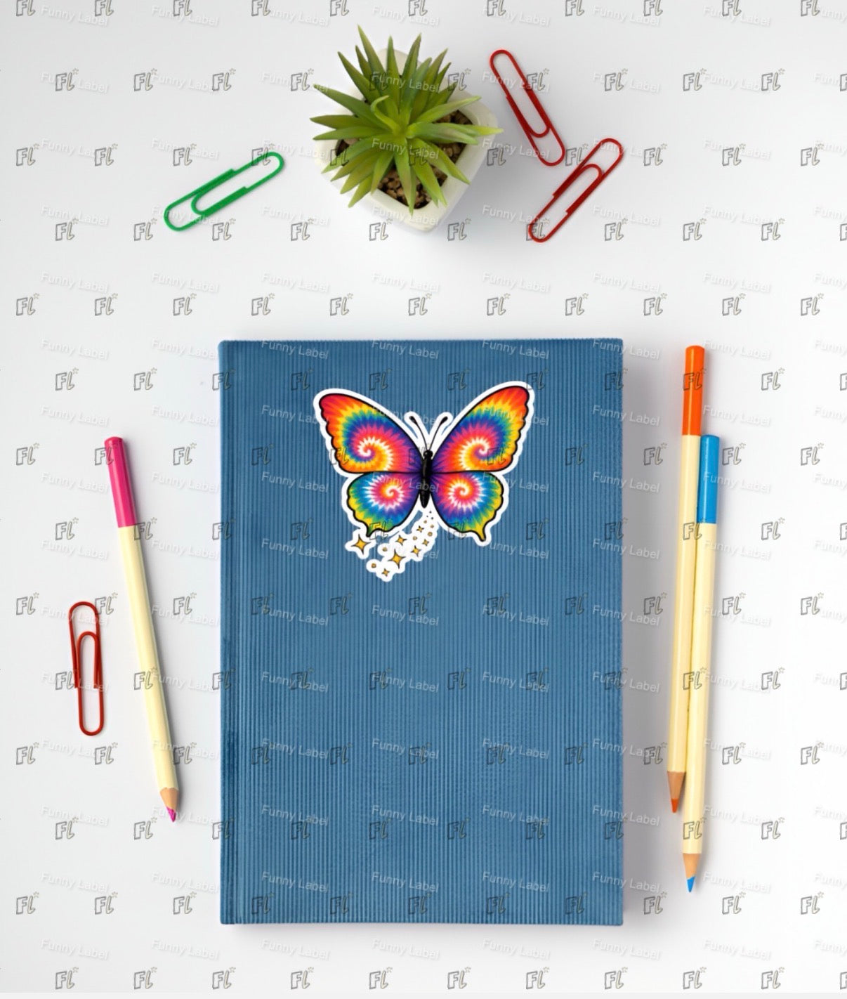 Blue notebook with a colorful butterfly design on a white background with stationery items.