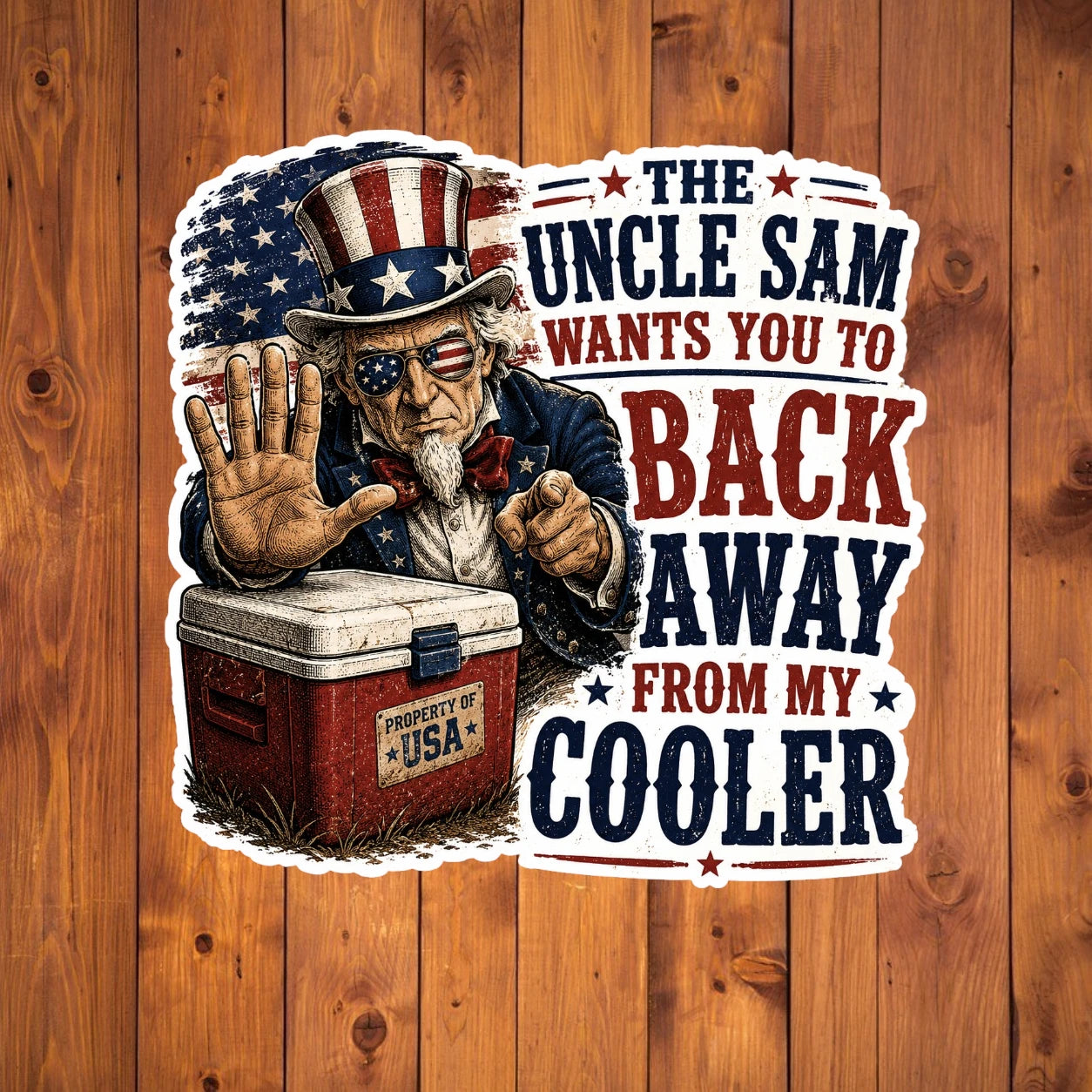 A flat, isolated vinyl sticker based on the file Back Away from my cooler with background.webp featuring a detailed vintage woodcut illustration of an intense Uncle Sam wearing American flag sunglasses, holding up a stop hand over a red ice chest labeled "PROPERTY OF USA", next to bold red and blue text reading "THE UNCLE SAM WANTS YOU TO BACK AWAY FROM MY COOLER".