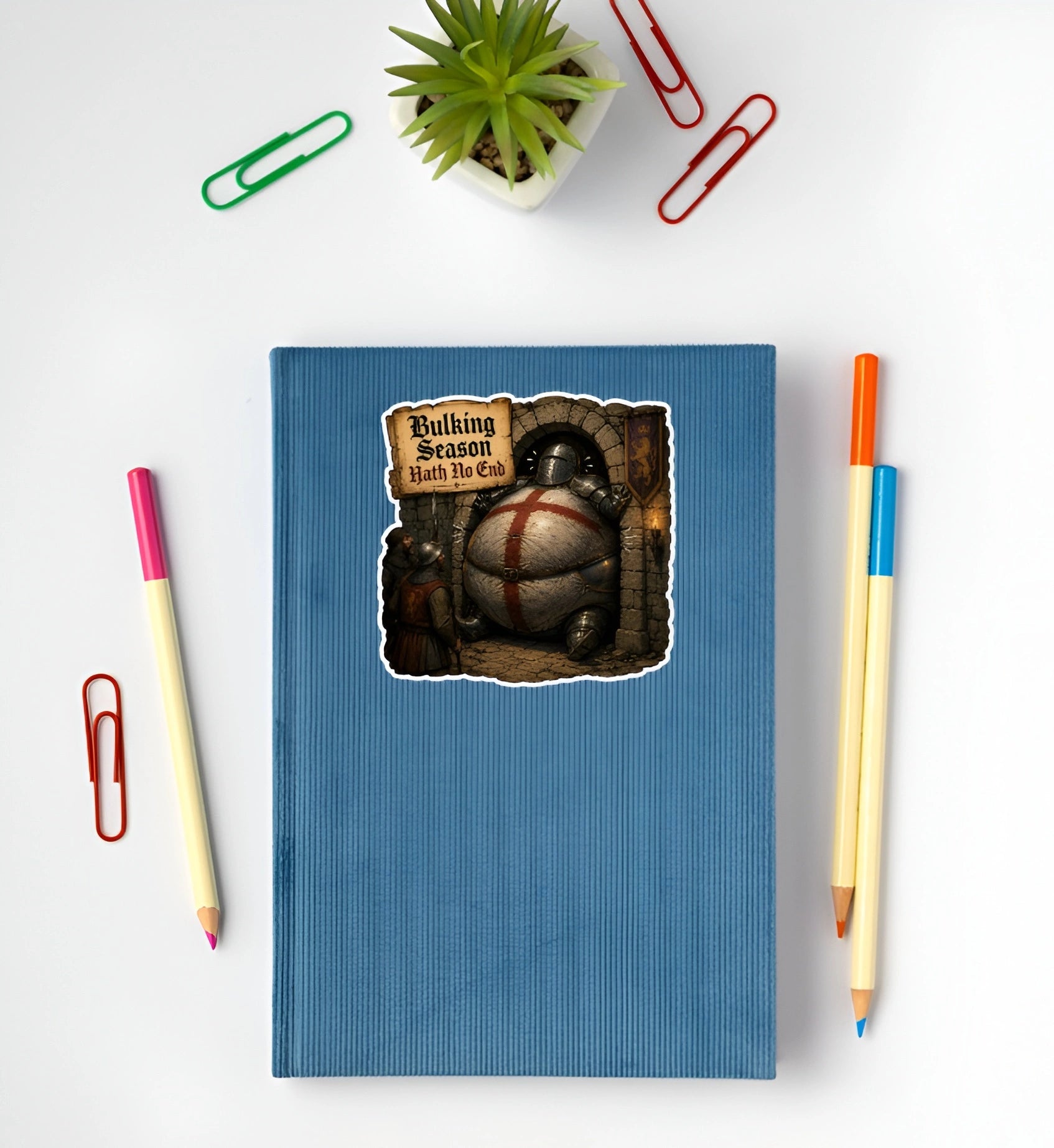 Bulking Season Hath No End medieval knight sticker displayed on a blue notebook featuring an oversized armored knight stuck in a doorway