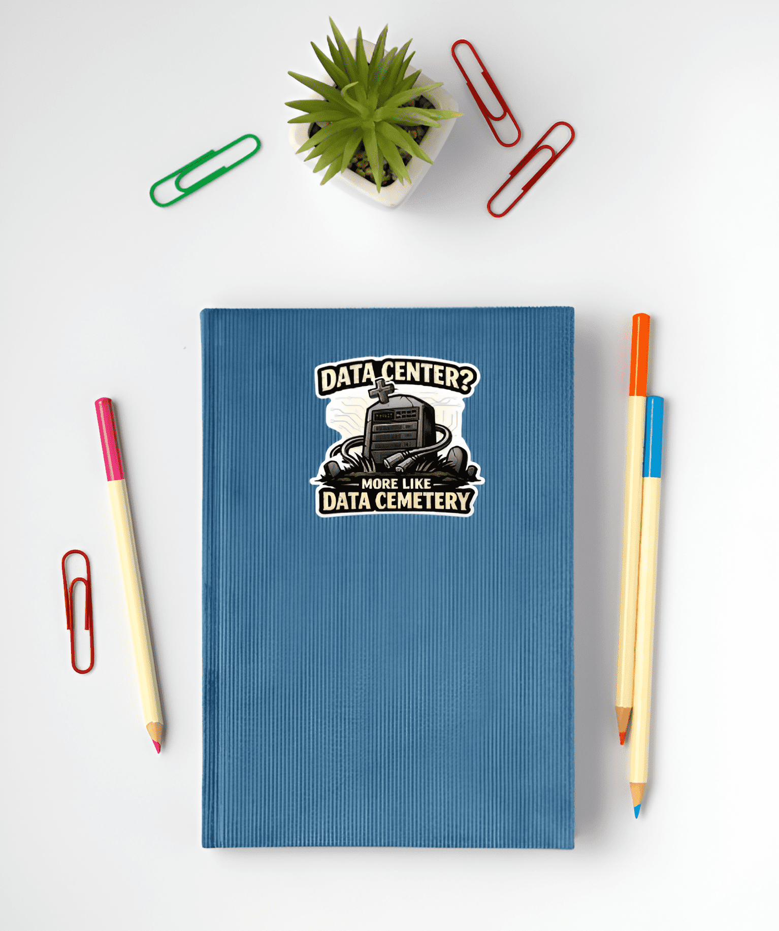 Blue notebook with a graphic design on a white surface with stationery items.