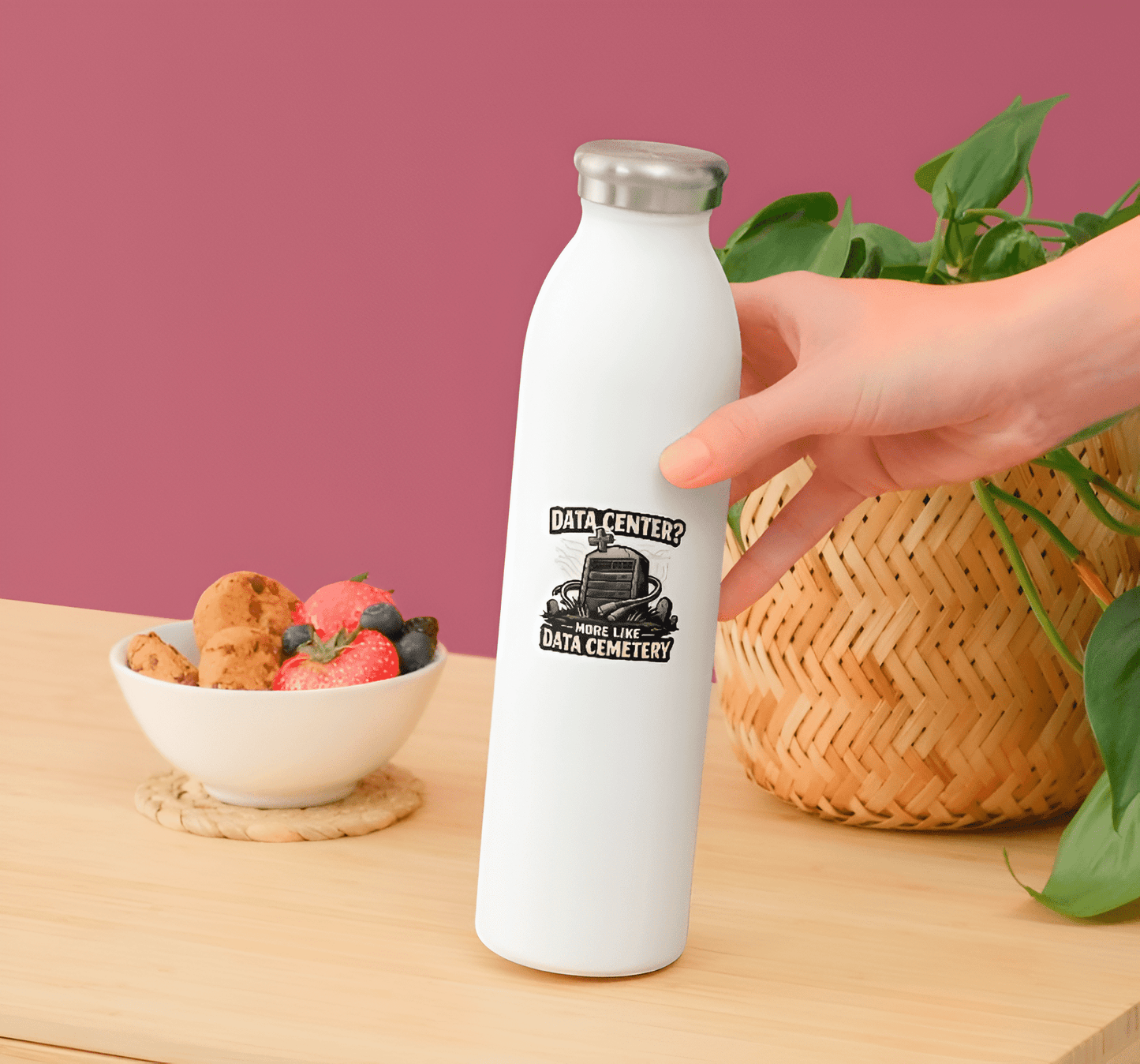 White water bottle with a humorous design held by a hand on a wooden table.