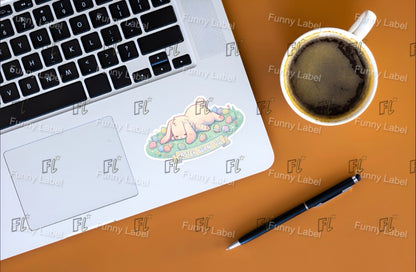 Laptop with a sticker on a wooden desk next to a cup of coffee and a pen.