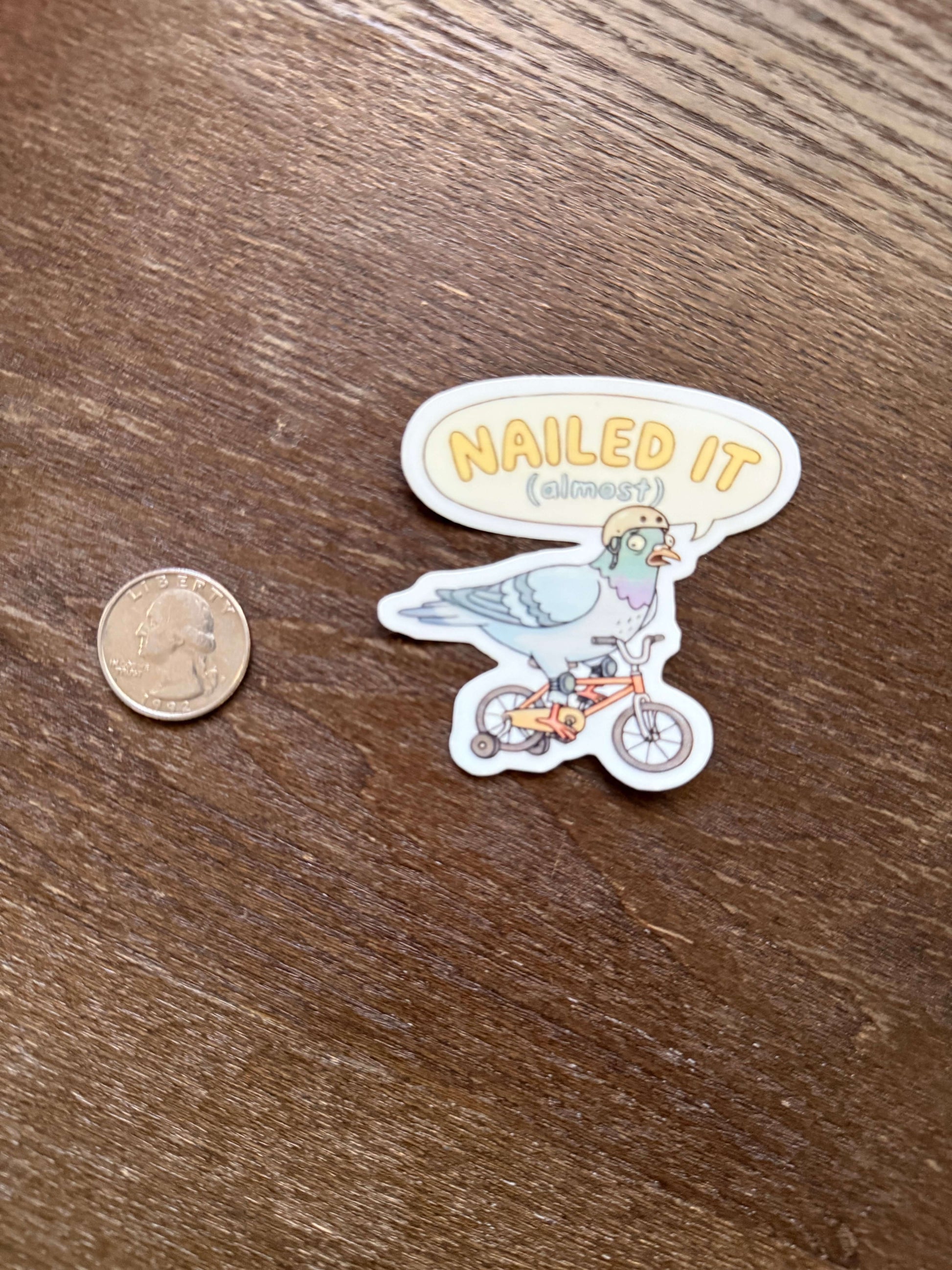 Sticker with 'MAILED IT' text and illustrations on a wooden surface