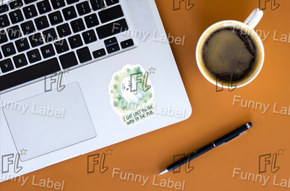 Laptop with a sticker on a brown surface next to a cup of coffee and a pen.