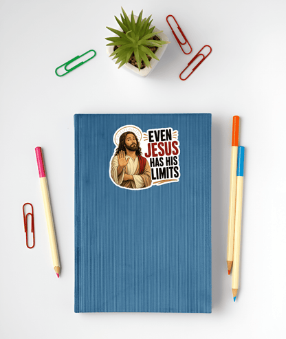 Blue notebook with illustration of Jesus with a thin gold halo, wearing cream and red robes, holding up one hand in a stopping gesture with a tired expression next to bold stacked text reading "EVEN JESUS HAS HIS LIMITS"., surrounded by stationery items on a white background.