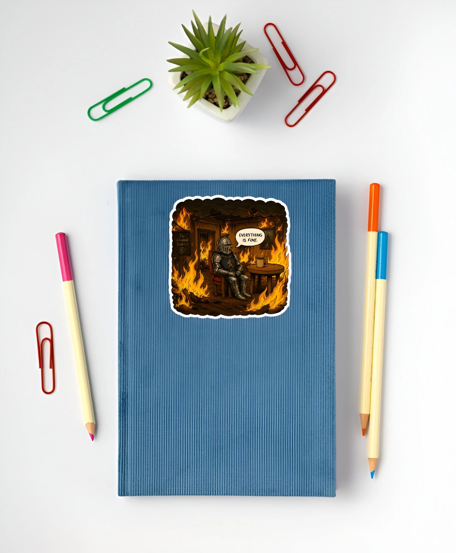Everything Is Fine medieval knight sticker displayed on a blue notebook