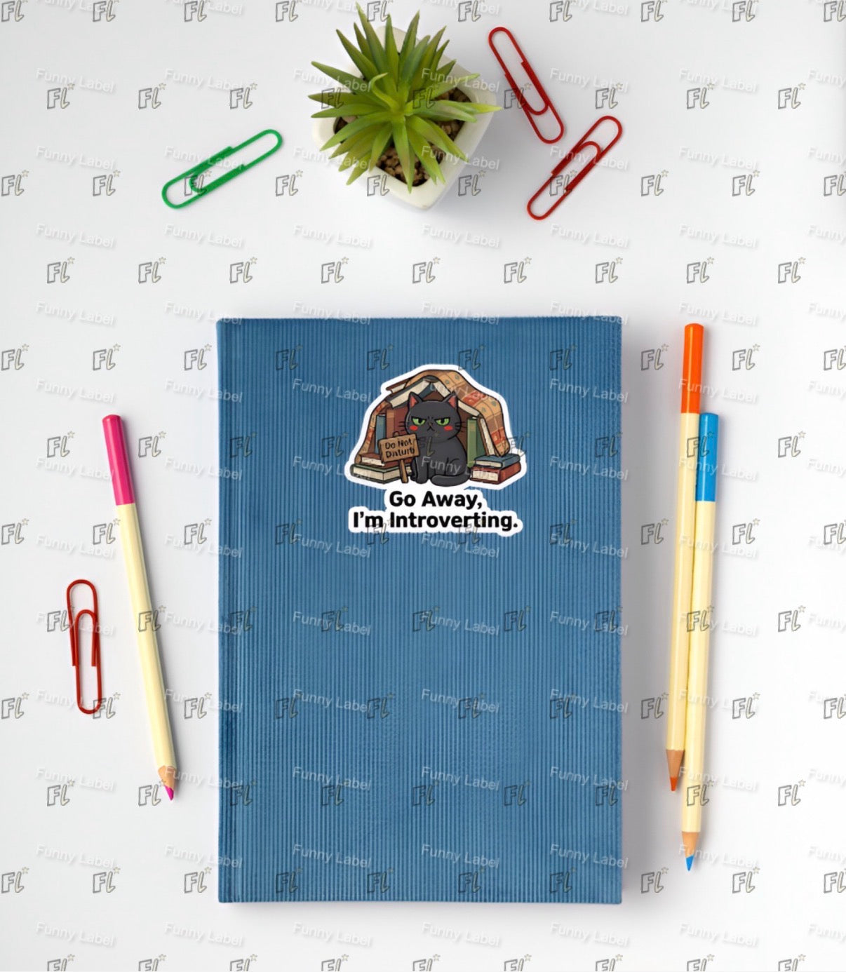 Blue notebook with a cartoon illustration and text, surrounded by stationery items on a white background.