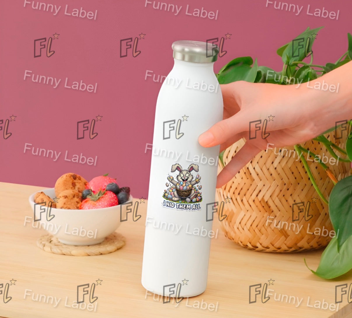 White water bottle with a cartoon character label, held by a hand on a table with snacks and plants.