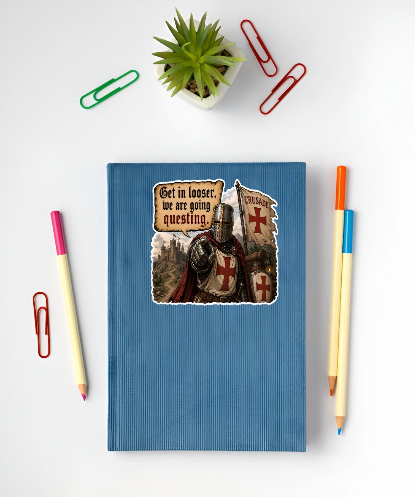 Get In Looser We Are Going Questing sticker displayed on a blue notebook