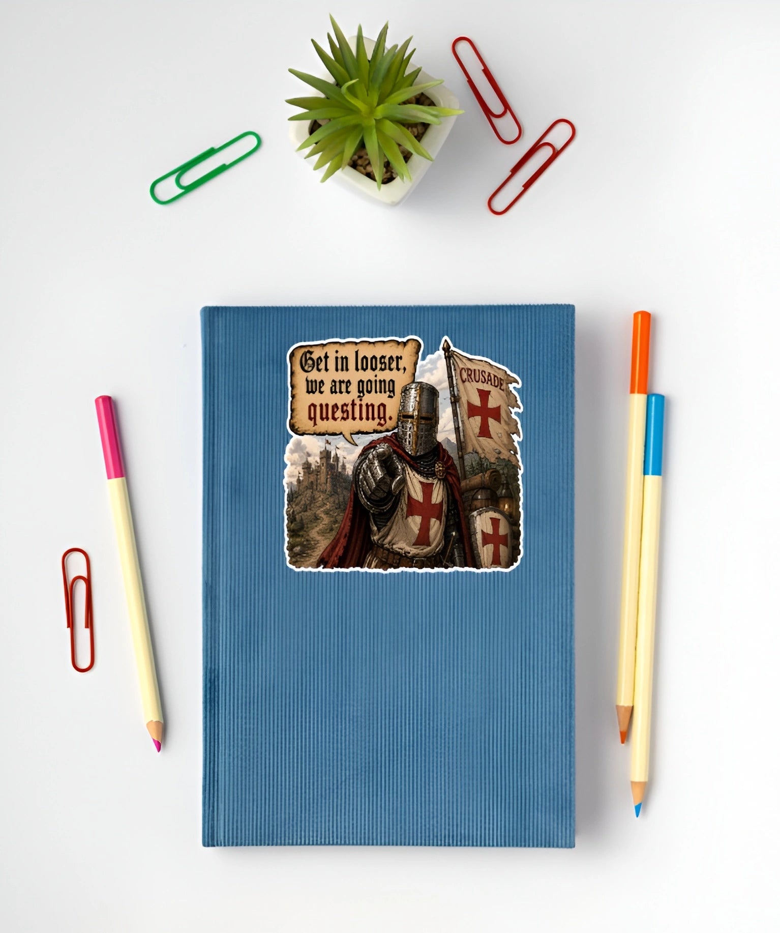 Get In Looser We Are Going Questing sticker displayed on a blue notebook