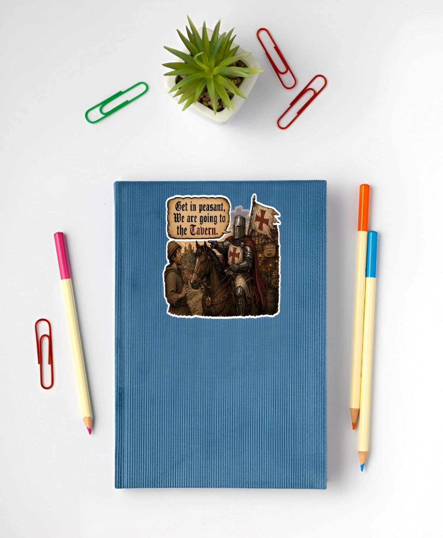 Get In Peasant We Are Going to the Tavern medieval knight sticker displayed on a blue notebook