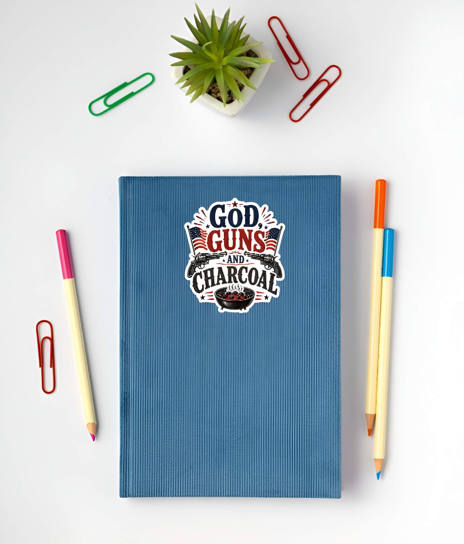 Blue notebook with a graphic design on a white surface with stationery items.