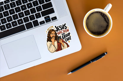 Jesus Has Seen Our Group Chat funny Christian sticker displayed on a silver laptop beside a coffee cup