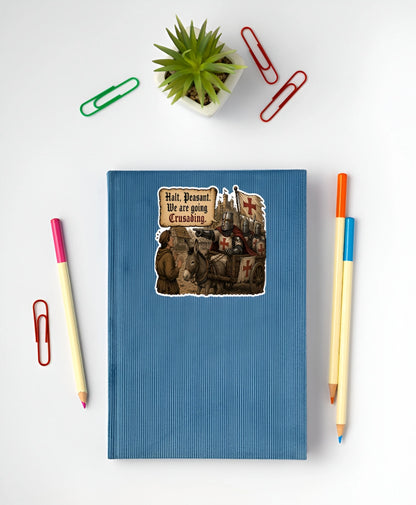 Funny medieval crusading sticker with knights and donkey cart displayed on a blue notebook