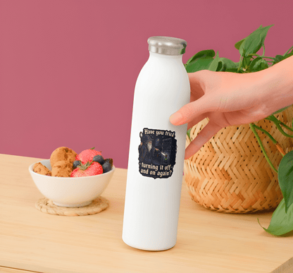 White water bottle with a design on a wooden table with a bowl of snacks and a plant.