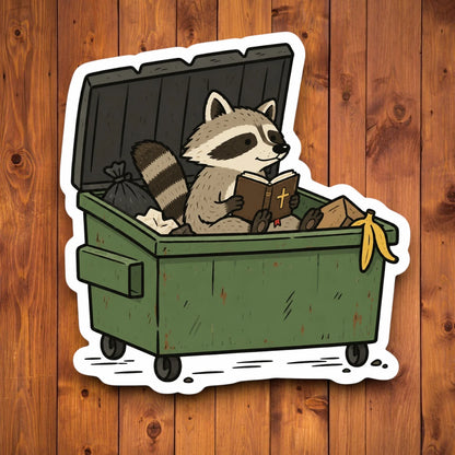 Cute raccoon sitting inside a green dumpster while reading a Bible in a funny Christian sticker design
